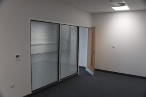 Office partitioning installation with a glass window partition and a door